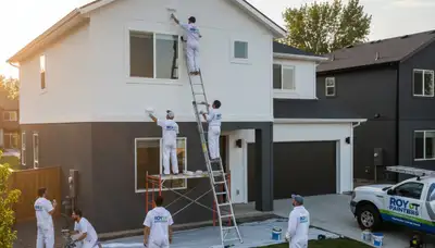 Professional house painters in Ogden UT applying exterior paint to a residential home